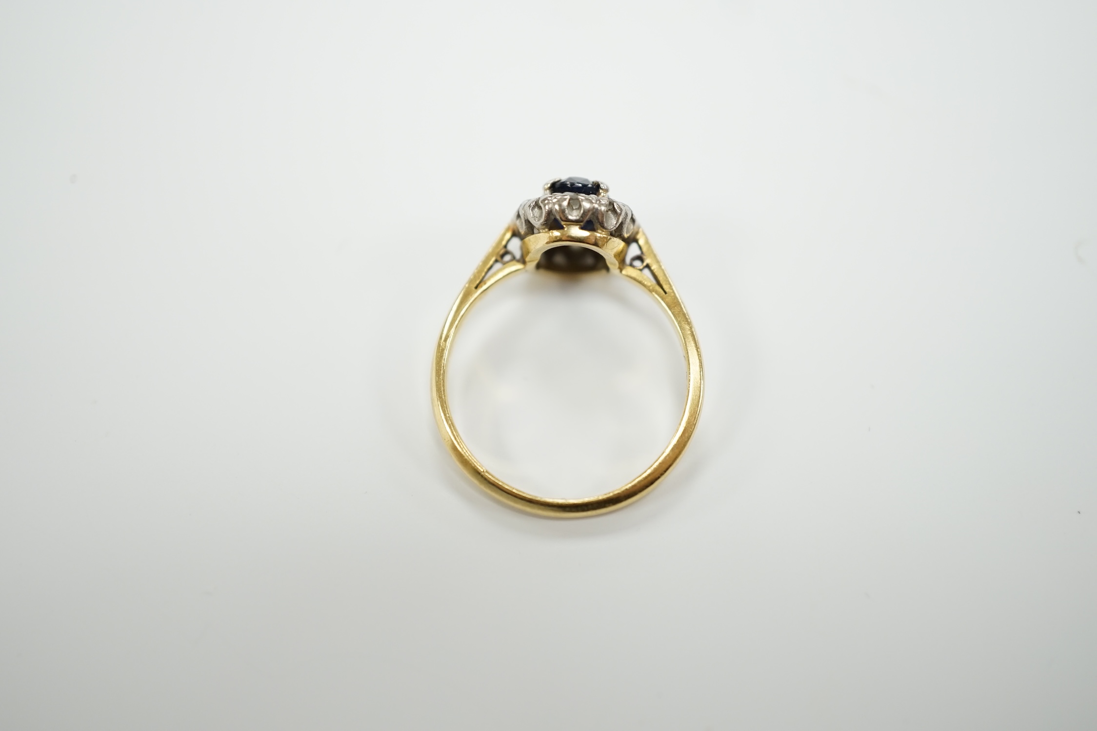 An 18ct, sapphire and diamond set oval cluster ring, size L, gross weight 2.5 grams.